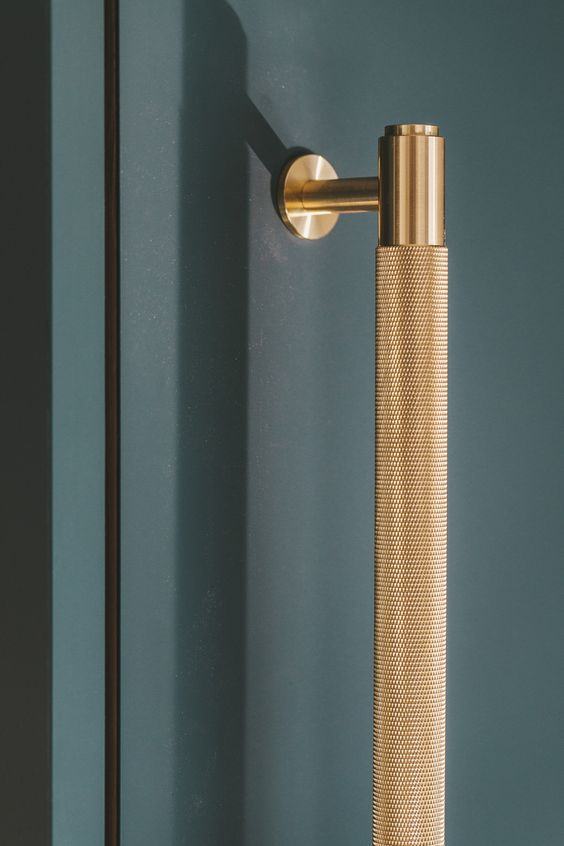 Knurled brass handle on teal door